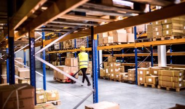 woman-warehouse-worker-with-hand-forklift-truck-PLH9ZG2.jpg